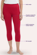 A model wearing dark pink capri leggings with text callouts pointing to the mid-waist, cusset crotch, stretchy fabric, and 3/4 length on a pale pink background.