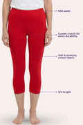 Red 3/4 length capri leggings shown on a model from the waist down, with purple text callouts highlighting features like mid waist, gusset crotch, stretchy fabric, and length.