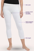White cropped leggings shown on a model from the waist down, with purple dotted callouts labeling mid waist, gusset crotch for extra durability, soft stretchy cotton fabric, and 3/4 length.