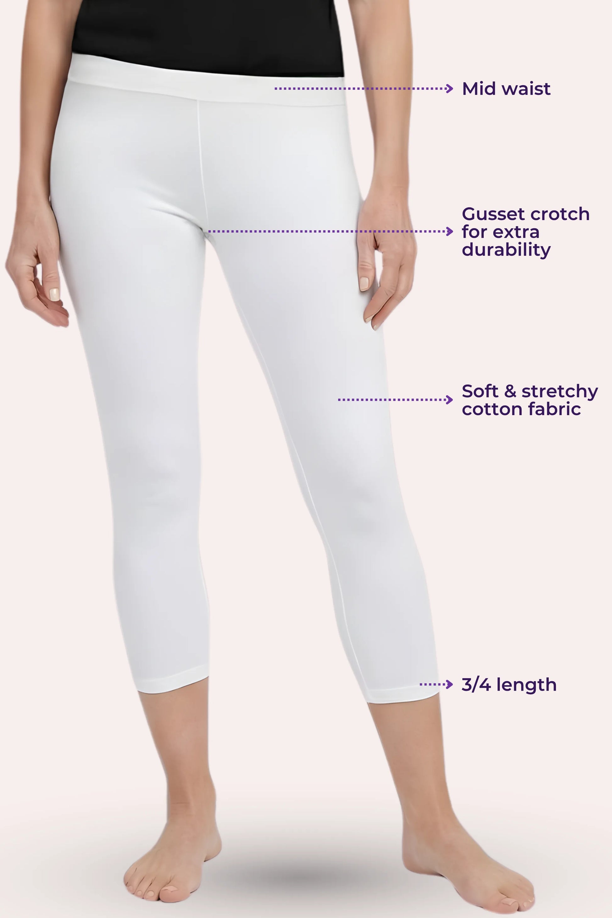White cropped leggings shown on a model from the waist down, with purple dotted callouts labeling mid waist, gusset crotch for extra durability, soft stretchy cotton fabric, and 3/4 length.