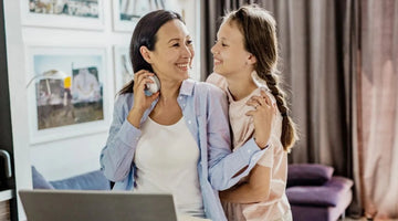 Image of a mom hugging her smiling daughter