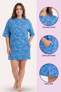 A woman model a blue floral nightshirt with side pockets and a closed neckline.