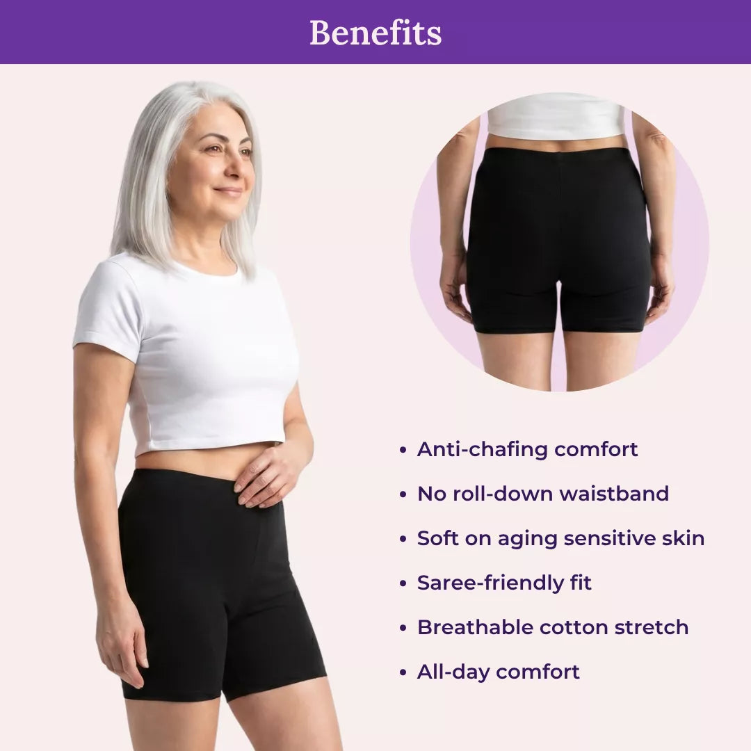 Woman wearing black shorts with product benefits listed on a light pink background