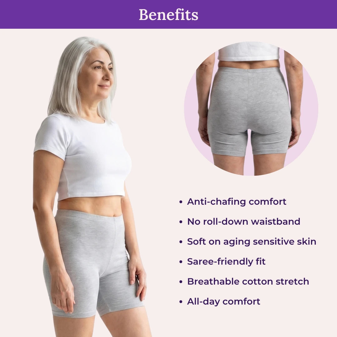 Woman wearing grey shorts with product benefits listed on a light pink background