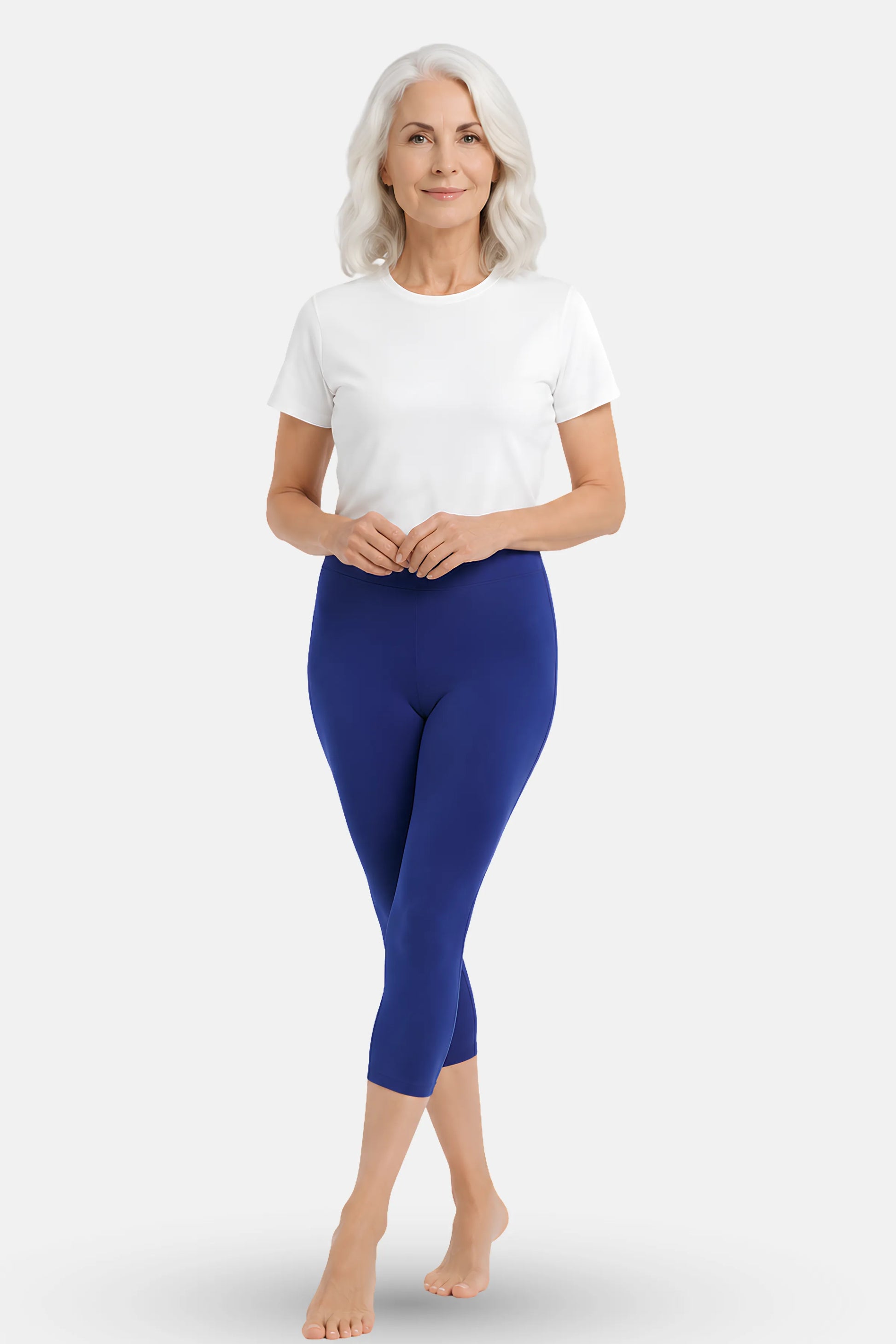 An elder woman wearing a plain white top and bright royal blue capri leggings.