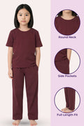 Girl wearing a wine outfit with round neck, side pockets, and full length fit features