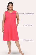 A woman modeling a sleeveless dark pink nightgown with a V-neck, side pockets, and knee-length.