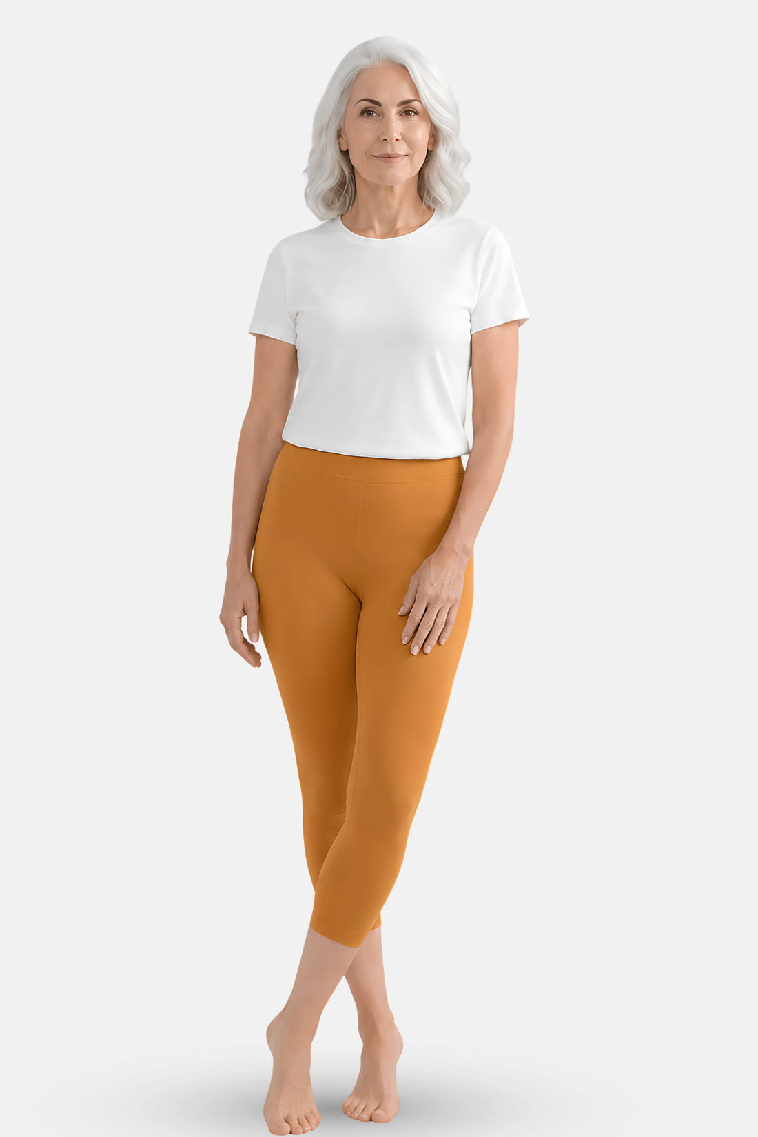 An elder woman wearing a white top and mustard-yellow cropped leggings.