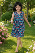 A young girl wearing a sleeveless V-neck dress with a blue floral aop.