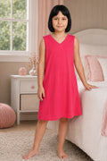 A girl wearing a sleeveless, V-neck dark pink nightgown.