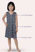 A girl modeling a sleeveless knee-length dress with a black pattern with callouts features.