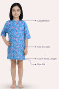A girl model wearing a blue floral nightgown with features: closed neck, side pockets, above knee length, and side slit.