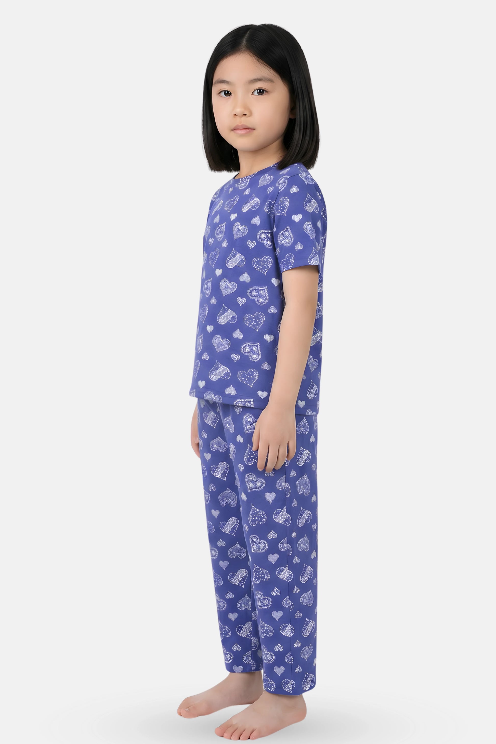 Girls wearing a navy hearts pajama set with white patterns