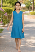 A young girl wearing a sleeveless blue V-neck dress