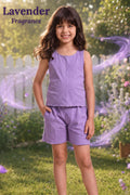 A young girl stands outdoors in a garden wearing a lavender sleeveless top and matching shorts. The image has a 'Lavender Fragrance' text overlay in the top left corner and purple magical swirl graphics on both sides.