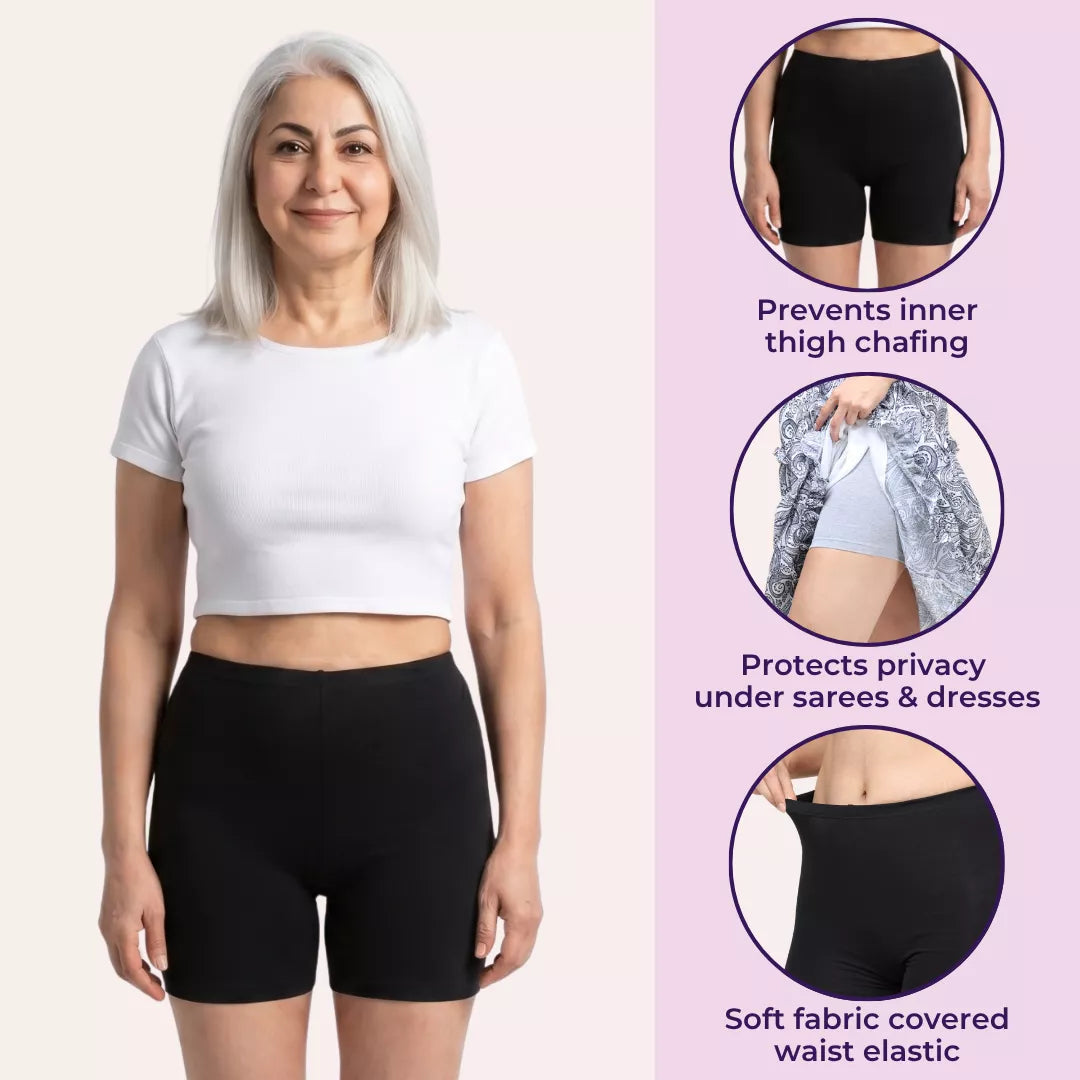 Woman wearing a white crop top and navy blue shorts on a white background