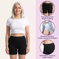 Woman wearing black shorts with product features highlighted on a pink background