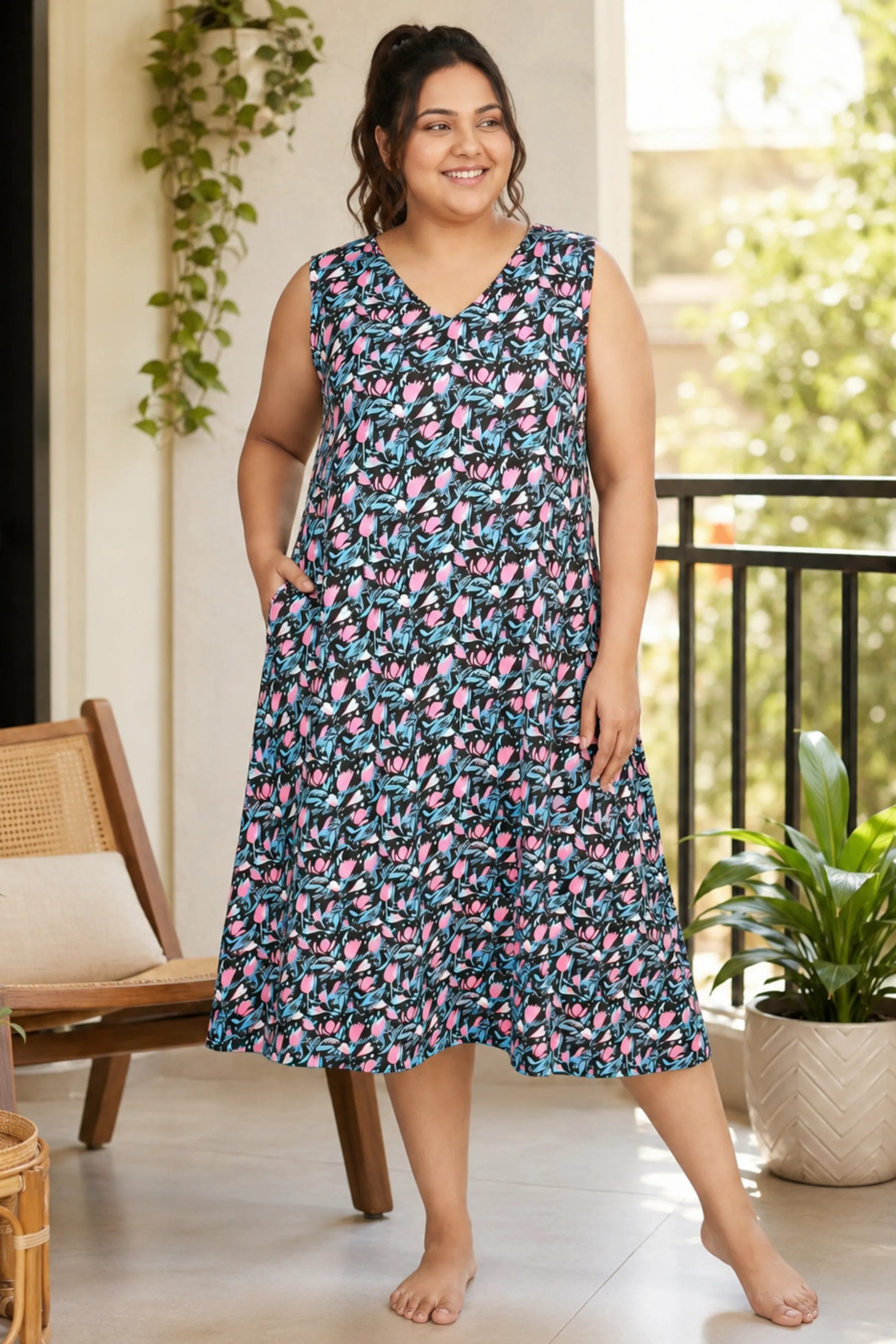A woman modeling a sleeveless dress with a black print
