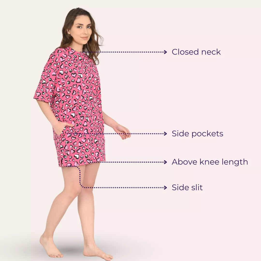 Woman wearing a candy heart oversize t shirt with text labels pointing out features like closed neck, side pockets, above-knee length, and side slit.