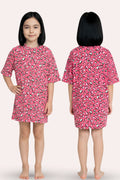 A girl modeling a pink nightgown with a hearts print, shown from both the front and back views.