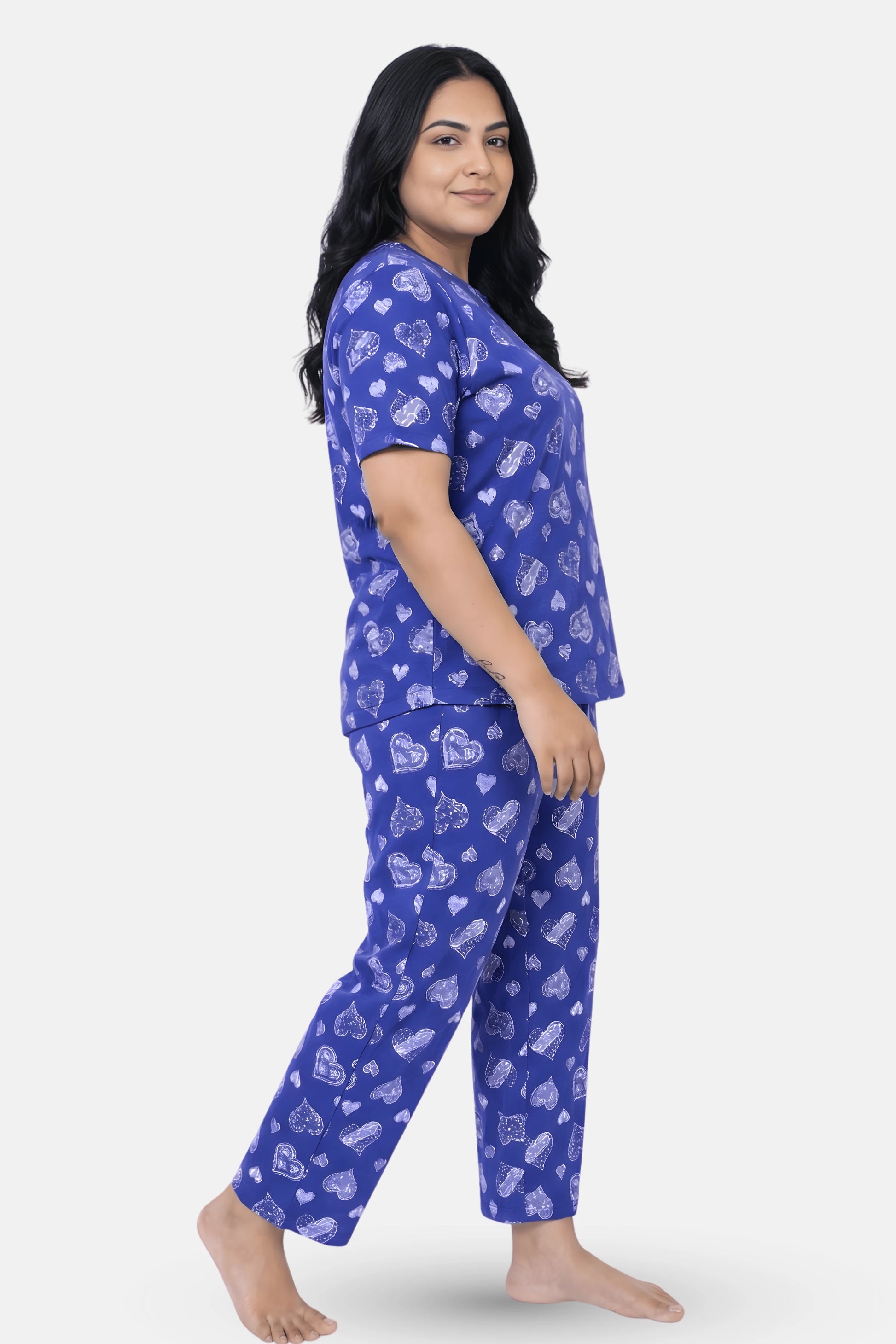 Woman wearing a navy hearts pajama set with white patterns