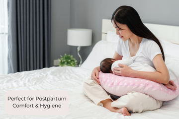 Woman holding a baby with a nursing pillow on a bed, text 'Perfect for Postpartum Comfort & Hygiene'.