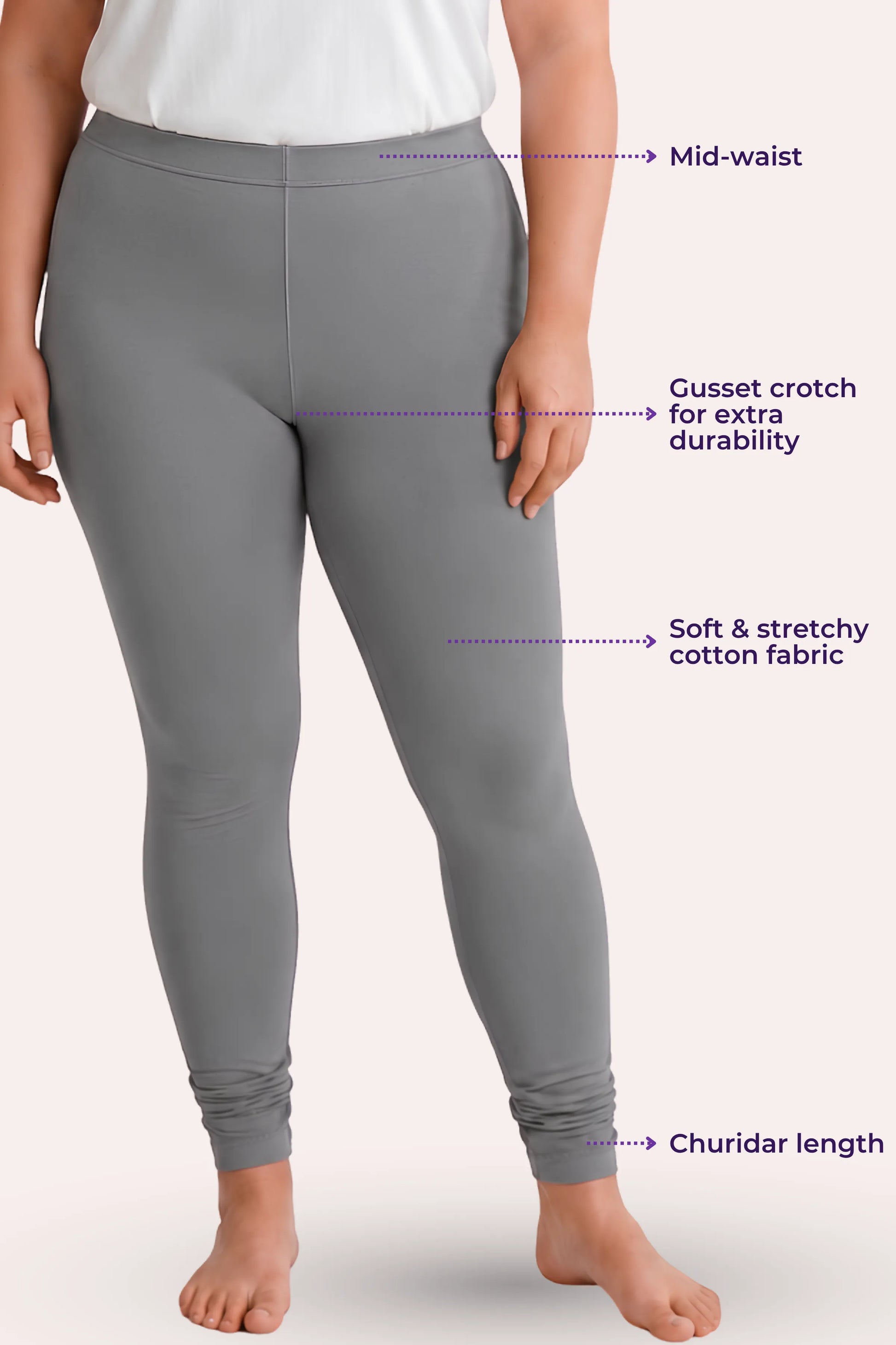 A model wearing gray churidar leggings with text callouts pointing to features such as mid-waist, gusset crotch, soft stretchy fabric, and churidar length.