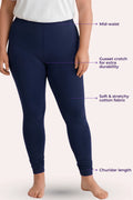 A model wearing navy blue mid-waist leggings with text callouts pointing to the waistband, gusset crotch, stretchy fabric, and churidar length against a light pink background.