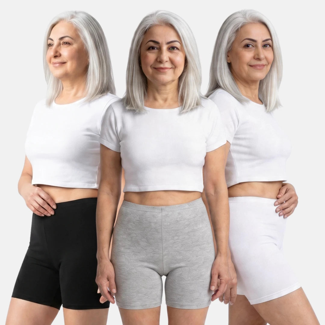 Woman wearing a three different poses with white crop top and black, grey & white shorts on a white background