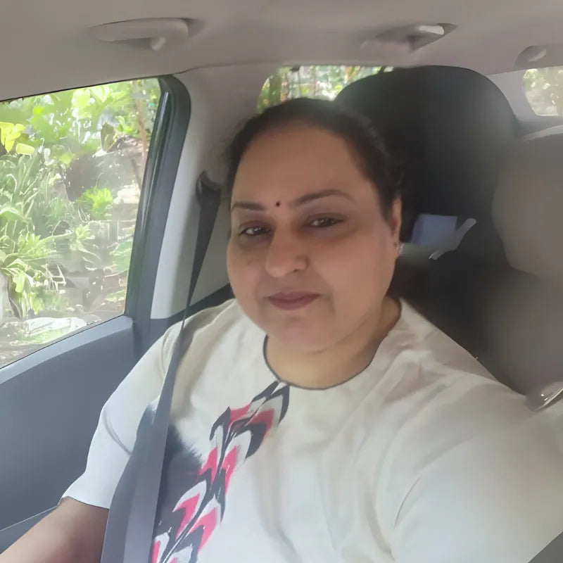 Woman sitting inside a car with greenery outside