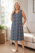 A elder woman wearing a sleeveless V-neck nightgown with black floral pattern