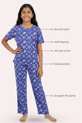 Teen wearing a navy pajama set with heart patterns, labeled features