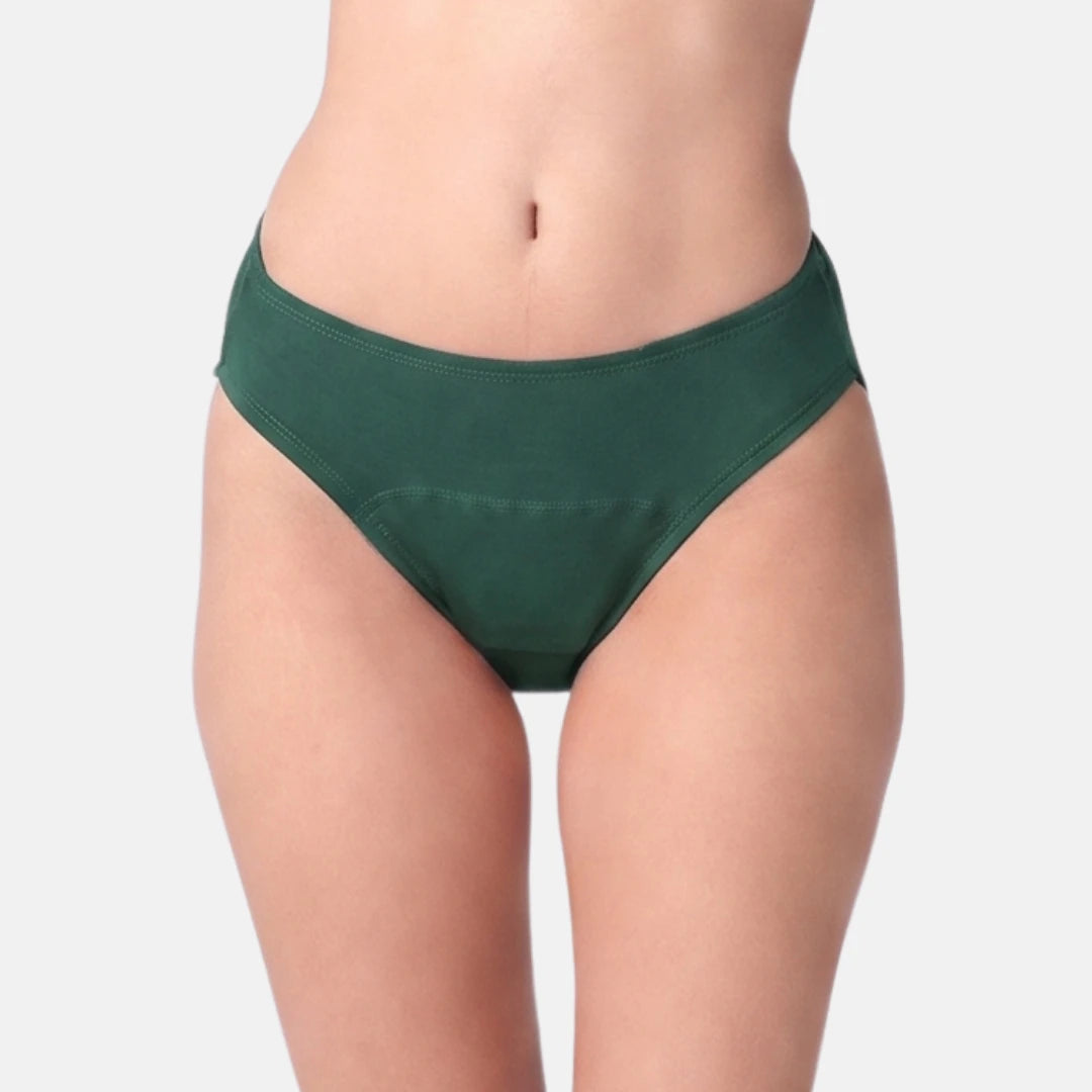 A model wearing a pair of dark green hipster against a light gray studio background.