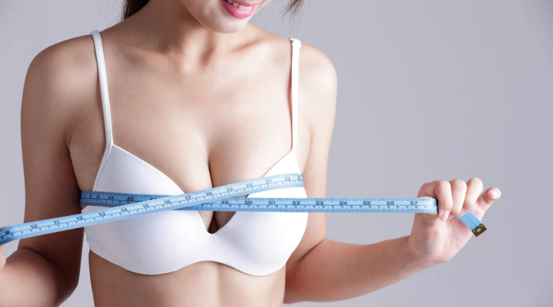 Image of women wearing white bra and measuring bra size