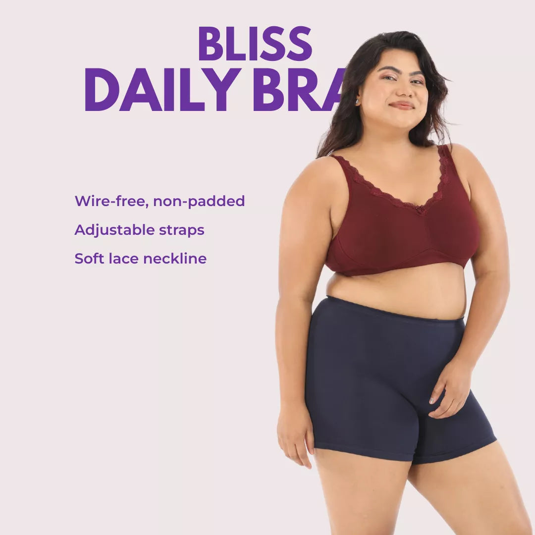Woman wearing a maroon bra and black shorts with product features listed on a light pink background.